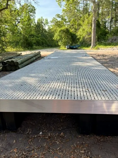 Freshly fabricated aluminum dock section with grated decking staged on site