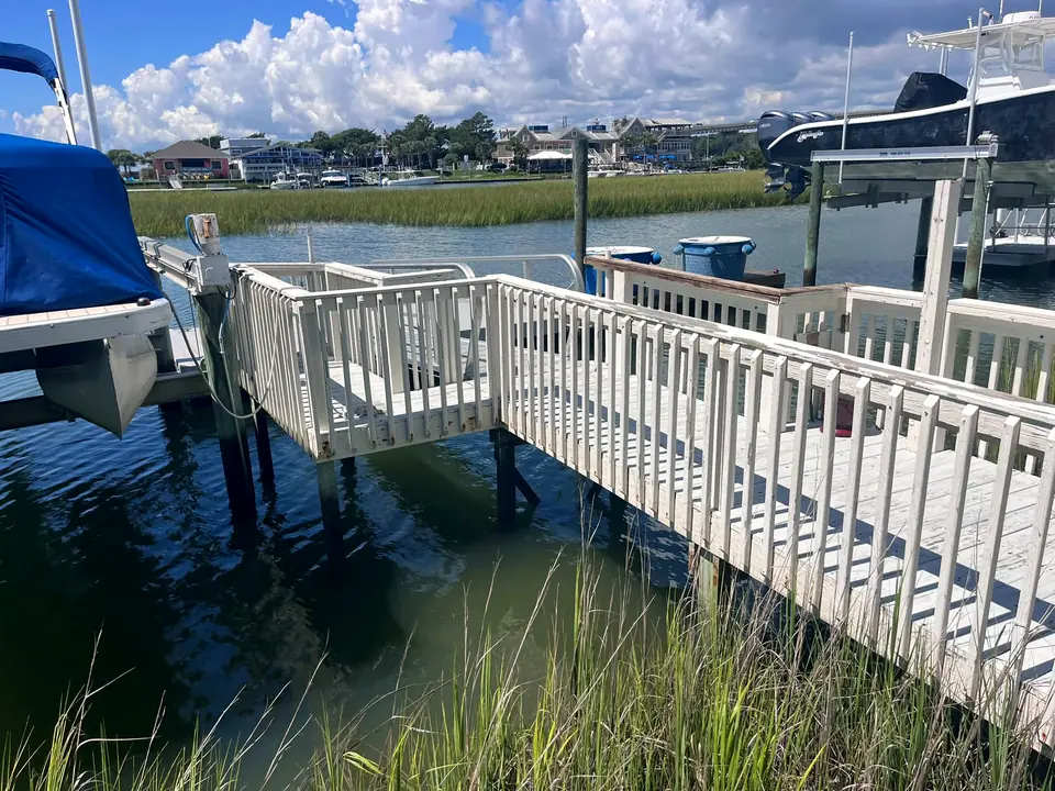 Before: aging wooden walkway and railings beside a boat lift