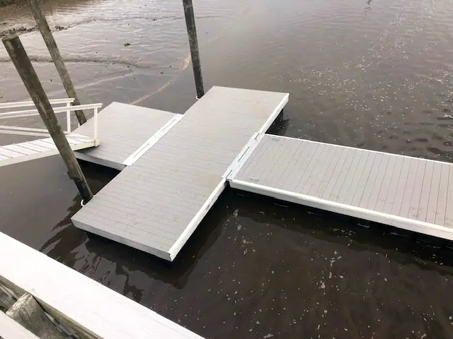 Aluminum floating dock sections joined in a T layout on the water