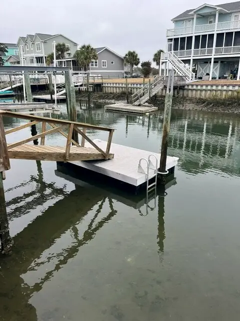 Floating dock with wood railings and a ladder on a canal