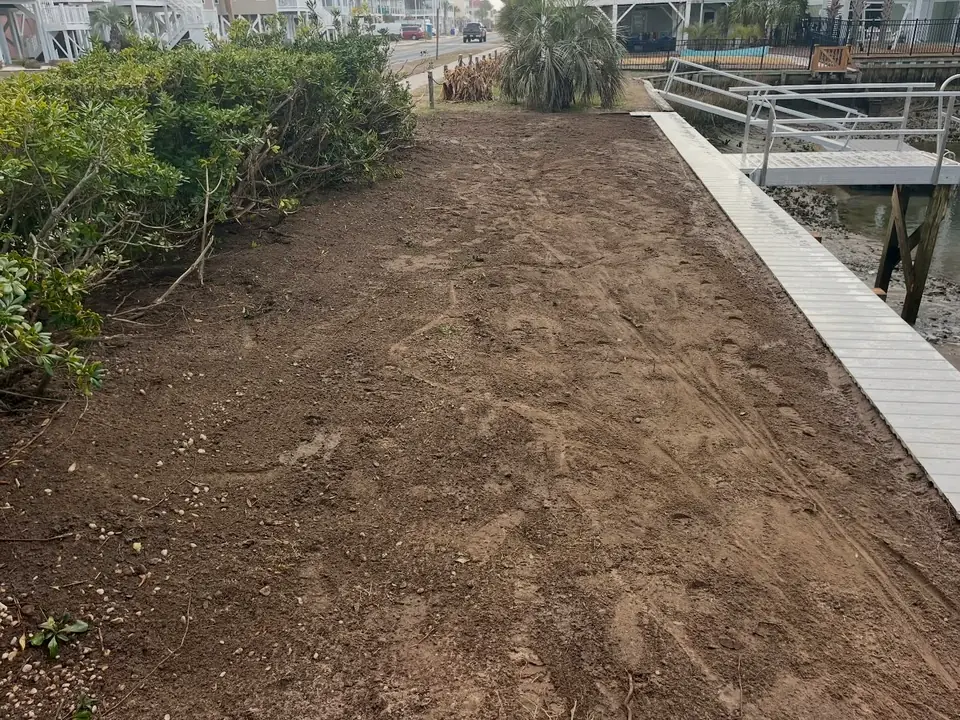 Graded backfill behind a new seawall beside an aluminum walkway