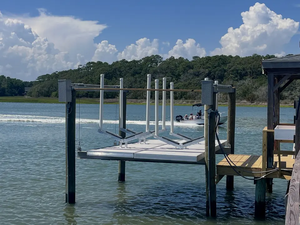 Two custom aluminum jet ski cradles on a boat lift over the water