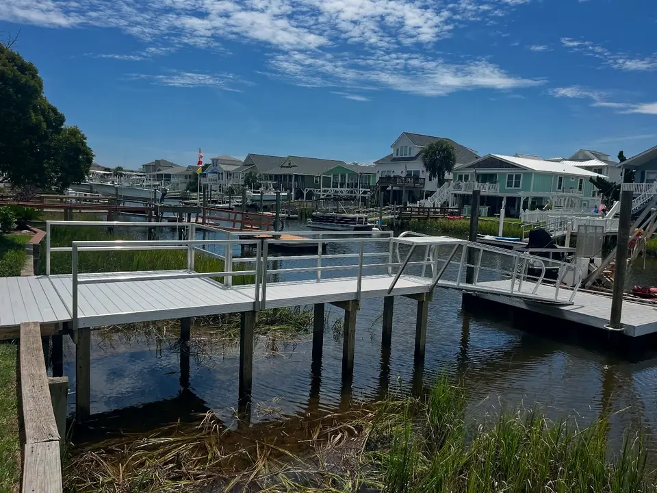 Aluminum pier and platform over marsh in front of canal-front homes