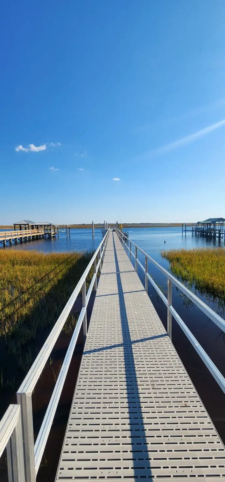 A 206-foot aluminum pier stretching straight across the marsh to open water