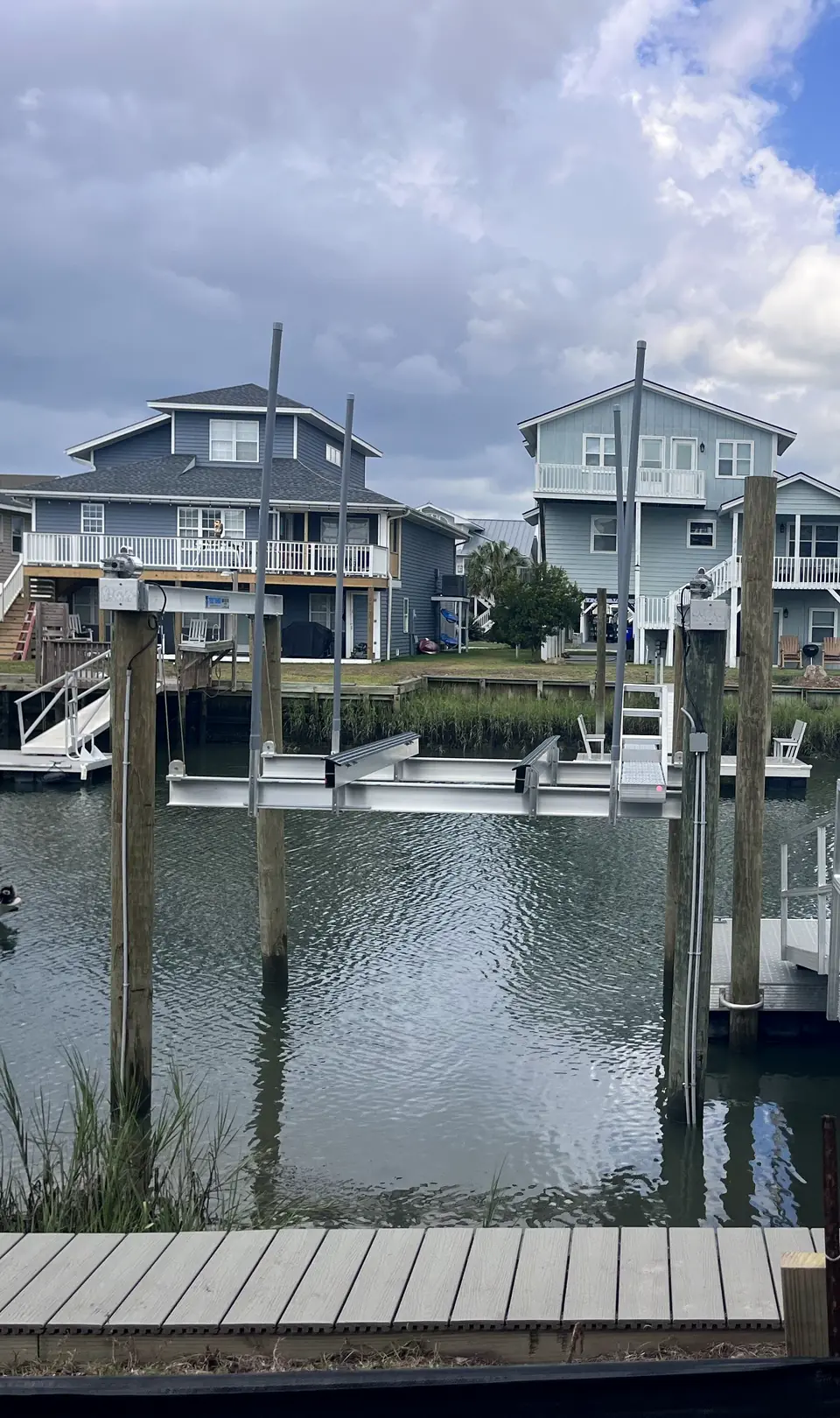 Vinyl seawall and floating docks lining a residential canal with beach homes behind