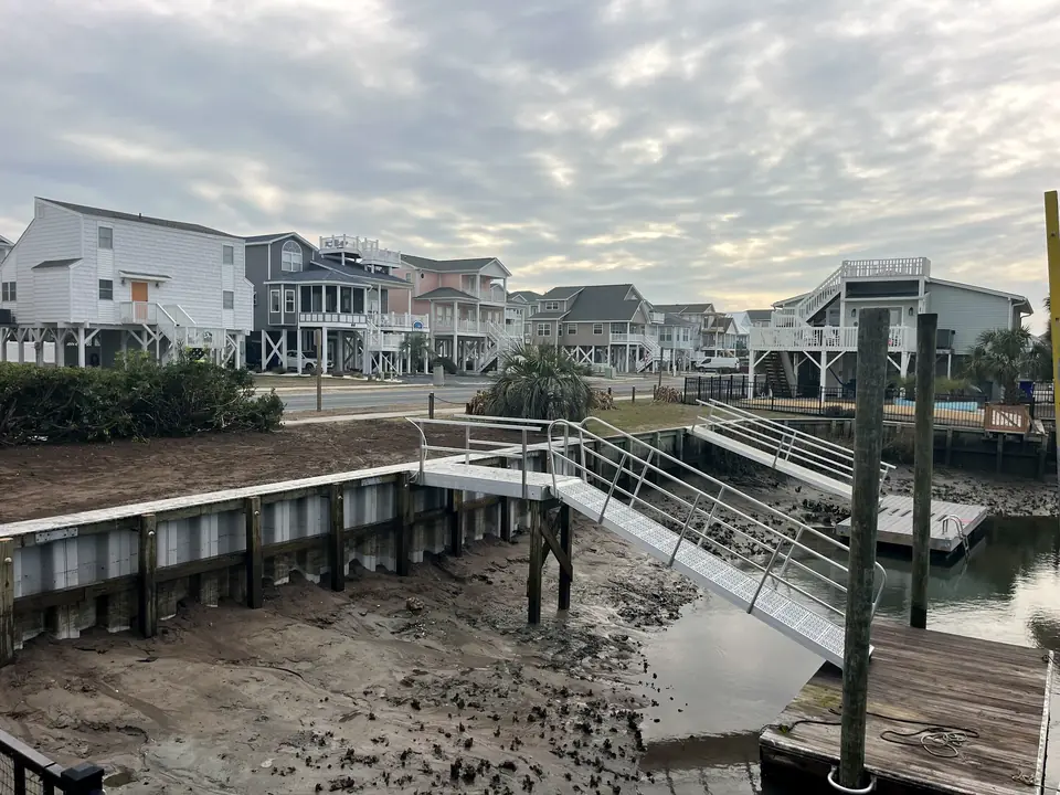 Finished vinyl seawall along a canal with an aluminum gangway leading down to a floating dock
